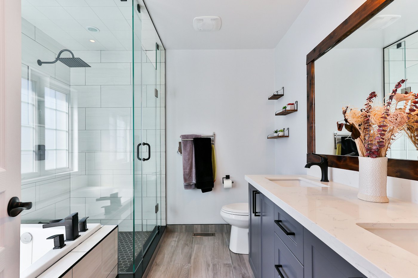 A newly fitted bathroom with a walk-in glass shower and double vanity